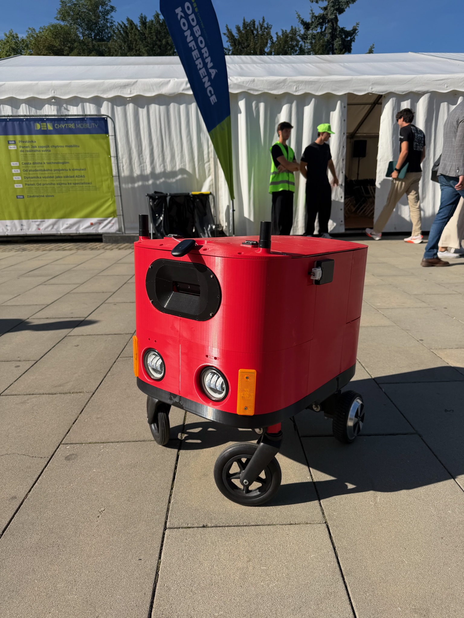 Červený autonomní robot Beruška při venkovním testování na výstavišti